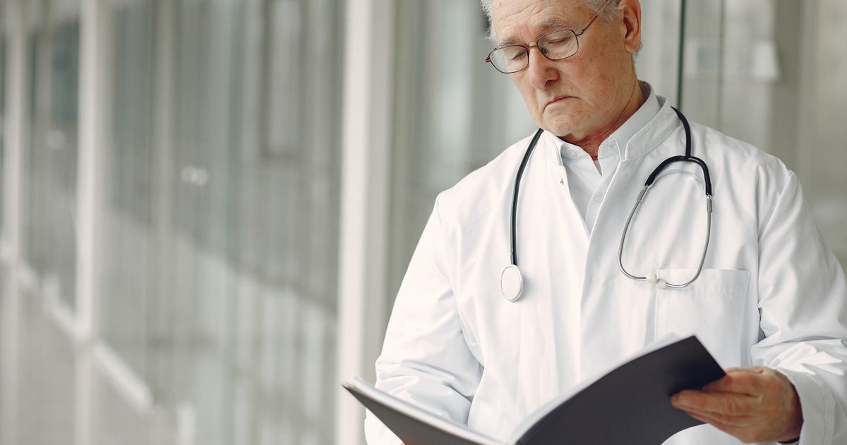 Profissional da saúde consultando registros para planejar a assistência