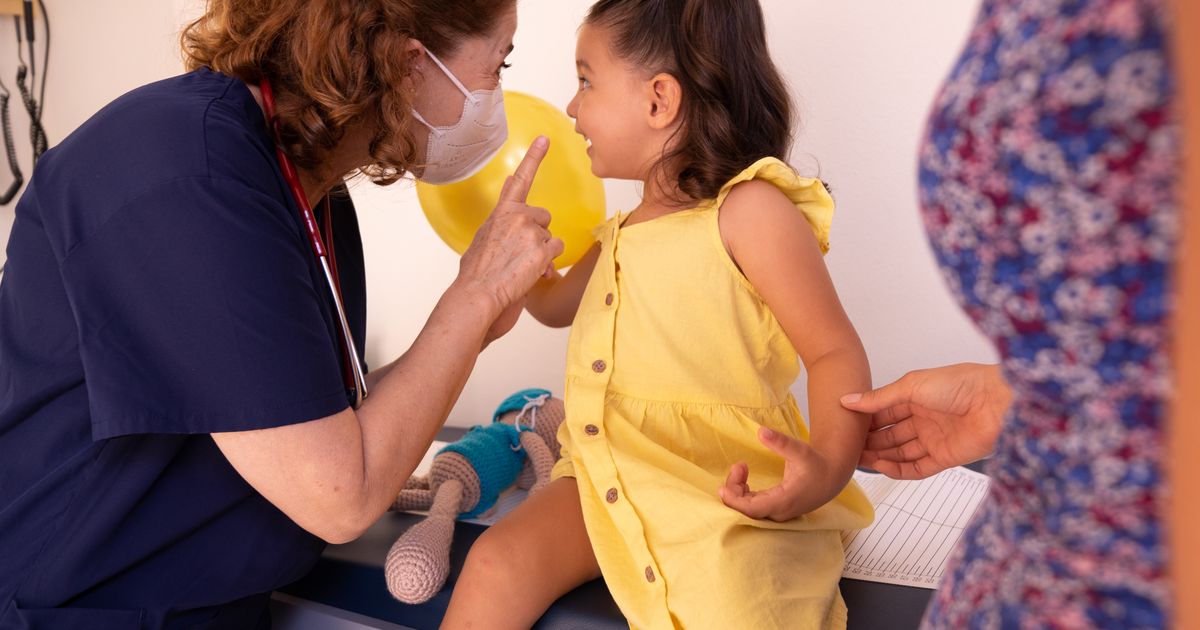 Profissional de saúde conversando com uma criança durante atendimento pediátrico